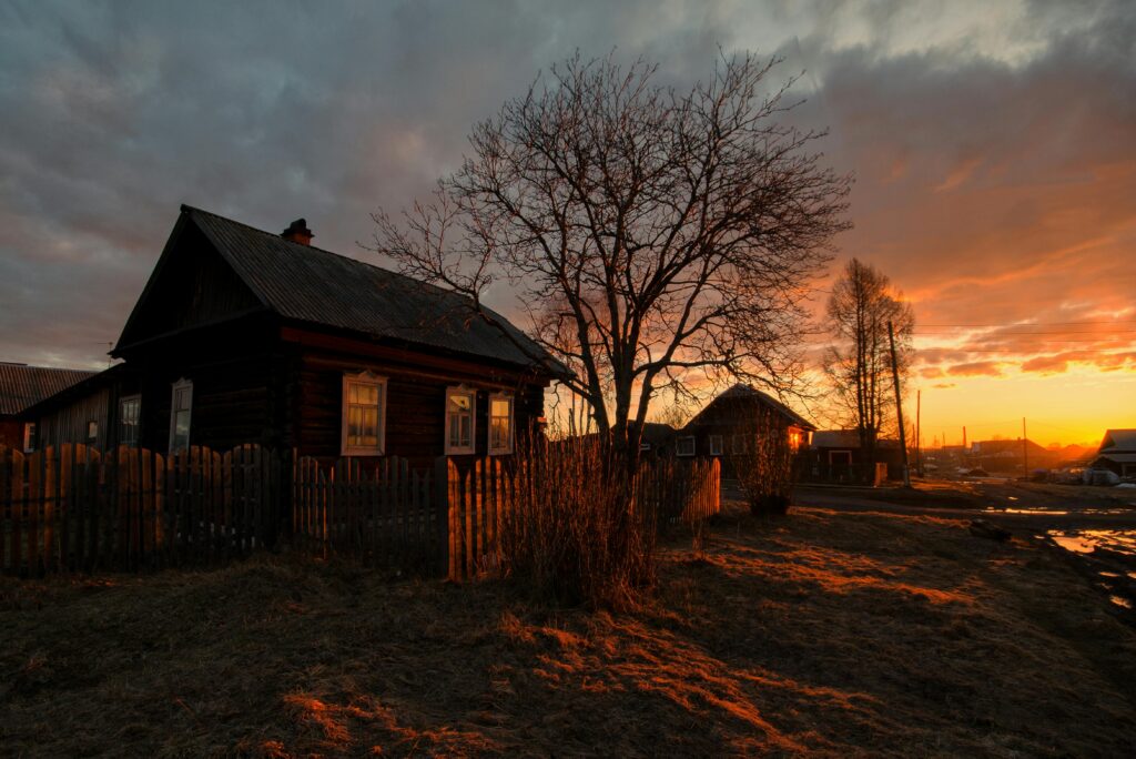 Scenic view of rustic village homes at sunset highlighting wooden cabins and tranquil countryside.